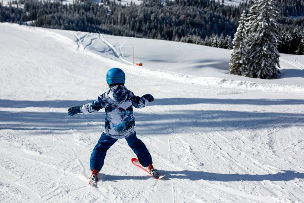 Carino bambino in età prescolare, sciare in località invernale austriaca su una clea — Foto Stock