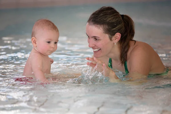 Pequeño bebé lindo, nadando felizmente en una piscina poco profunda — Foto de Stock