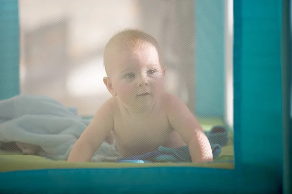 Mały chłopiec cute baby, bawi się zabawkami w łóżeczku mobilnych na su — Zdjęcie stockowe