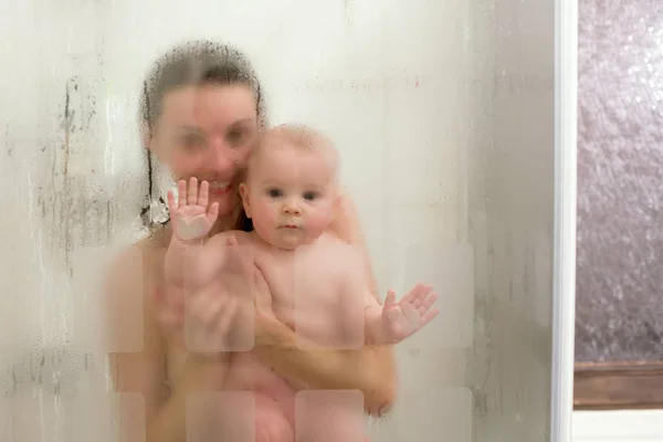 Mãe e menino no chuveiro, gotas de água — Fotografia de Stock