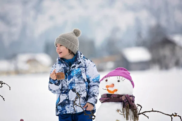 Famiglia con bambini, costruzione pupazzo di neve nel parco in poco male — Foto Stock