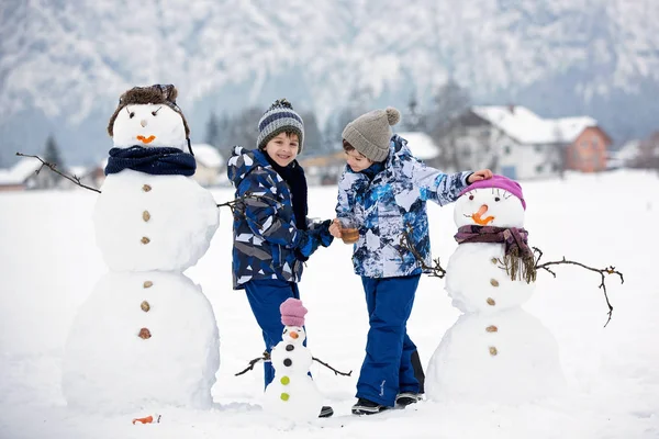 약간 에서 공원에서 눈사람을 건축 하는 아이 들과 가족 — 스톡 사진