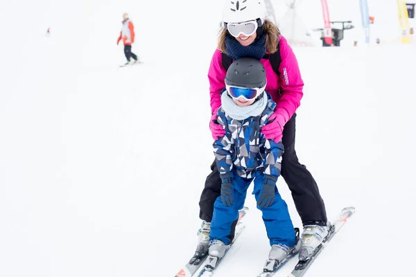 Krásná mladá maminka a její předškolní chlapce, lyžování horsk — Stock fotografie