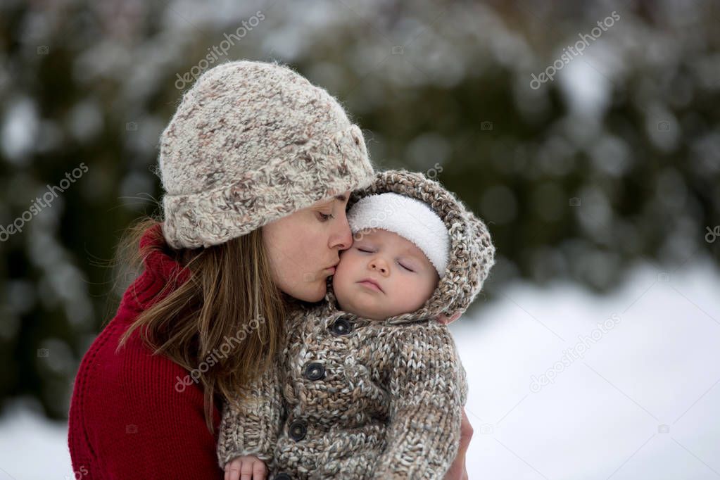 Beautiful mother and cute baby boy in knitted onesie, having tak