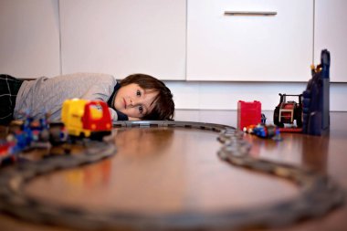 Bir oyuncak tren ile oturma odasında oynayan çocuk çocuk