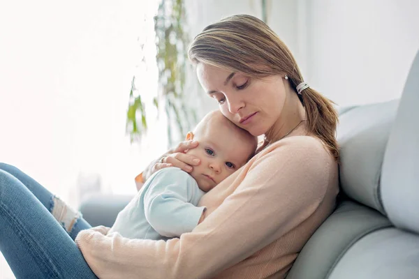 Fiatal anya, ő beteg totyogó fiú, átölelve neki otthon — Stock Fotó