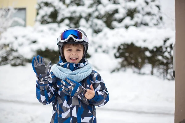 Ładny chłopak, grając z śniegu zimą ogród, — Zdjęcie stockowe