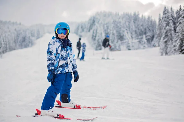 Carino bambino in età prescolare, sciare in località invernale austriaca su una clea — Foto Stock