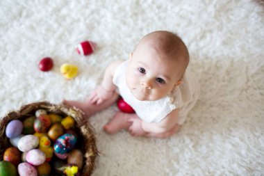 Renkli Paskalya yumurtaları ile oynayan sevimli küçük yürümeye başlayan çocuk oğlu, 