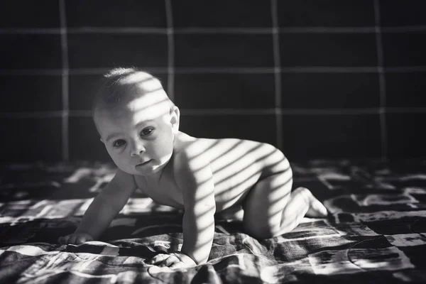 Niedliches Porträt eines kleinen Jungen im Bett, Sonne fällt auf — Stockfoto