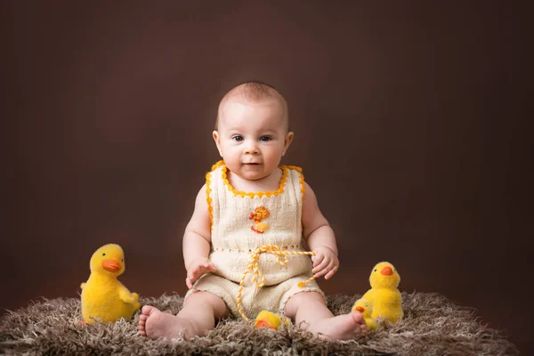 Little baby boy, playing with decorative ducks, isolated on brow — Stock Photo, Image