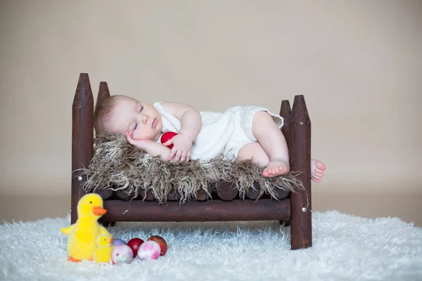 Cute little toddler baby boy, sleeping with colorful easter eggs — Stock Photo, Image