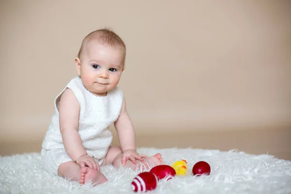 かわいい小さな幼児男の子、カラフルなイースターエッグと遊ぶ — ストック写真