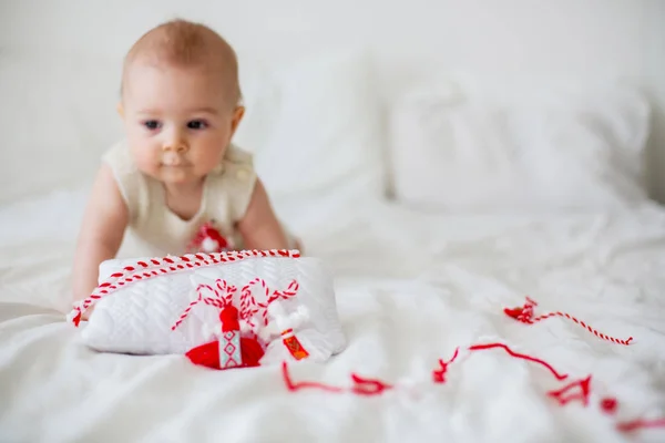 Cute baby toddler boy, playing with white and red bracelets — Stock Photo, Image
