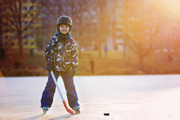 Çocuklar, hokey oynamak ve parkta donmuş gölde buz pateni, — Stok fotoğraf