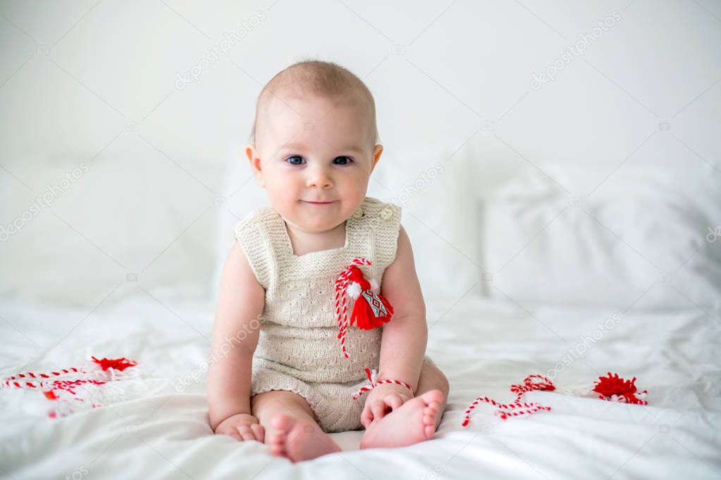  Cute baby toddler boy, playing with white and red bracelets