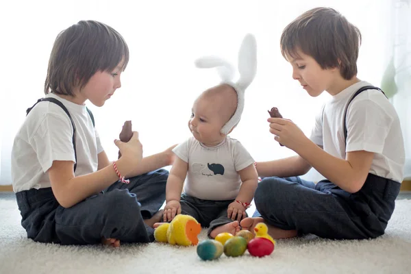 Три милых мальчика, братья, братья, играют с пасхальными яйцами, и — стоковое фото