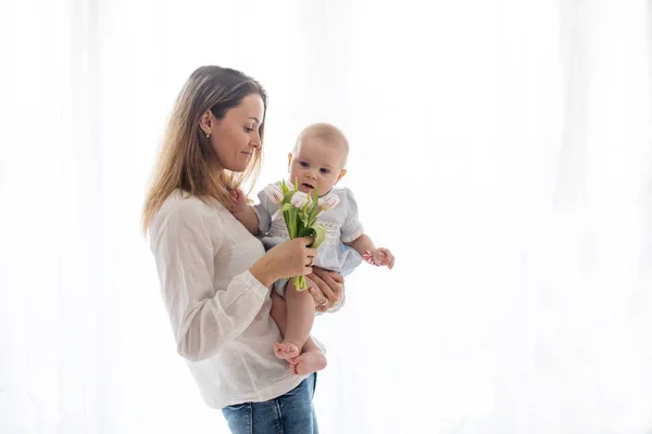 Aranyos kisfiú, gazdaság csokor friss tulipán az anya — Stock Fotó