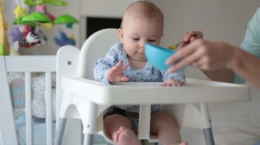 Gülümseyen püresi sebze yemek için onu tatlı yürümeye başlayan çocuk, beslenme anne şirin küçük oğlu,
