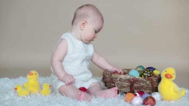 可爱的小学步婴儿男孩 玩五颜六色的复活节彩蛋和小装饰鸭子 孤立拍摄 米色背景 — 图库视频影像