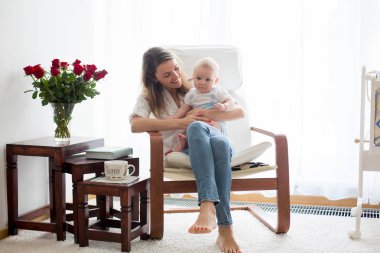 Anne, onun bebek çocuk sallanan sandalyede ile oynarken