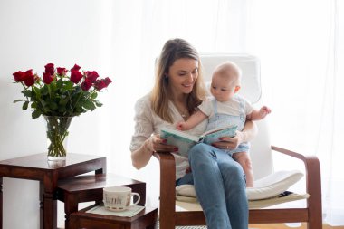 Anne, onun bebek çocuk sallanan sandalyede ile oynarken