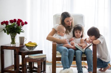 Anne, onun yürümeye başlayan çocuk ve büyük kardeşi oynayan okuyun