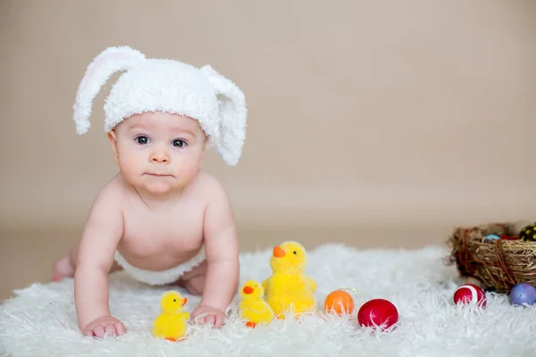 Bonito menino da criança, brincando com ovos coloridos de páscoa — Fotografia de Stock