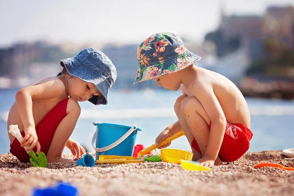Двоє милих дітей, грають на піску на пляжі — стокове фото