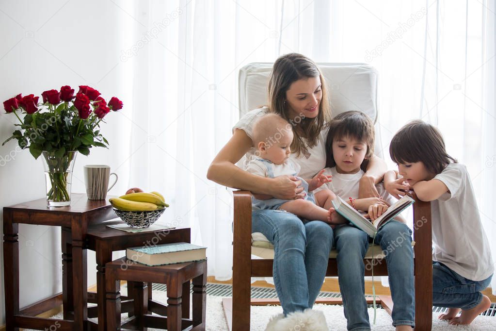 Mother, playing with her toddler boy and his older brother, read