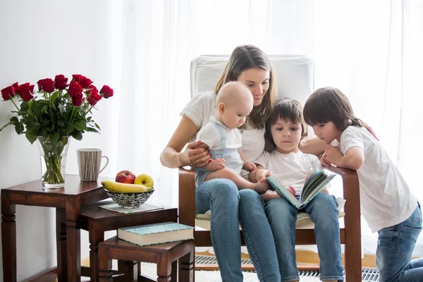 Moeder, spelen met haar peuter jongen en zijn oudere broer, lezen — Stockfoto