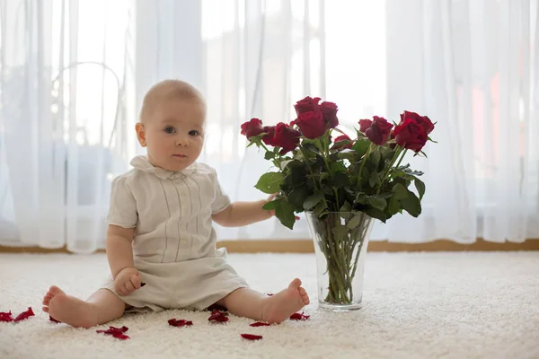 Piccolo bambino bambino carino bambino, seduto con rose per la mamma — Foto Stock