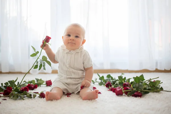 Pequeño bebé lindo niño, sentado con rosas para mamá —  Fotos de Stock