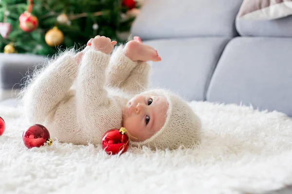 Little baby boy in white knitted onesie, playing with and openin — Stock Photo, Image