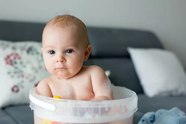 Aranyos kis négy hónapos kisfiát, játszik a vödör tele — Stock Fotó