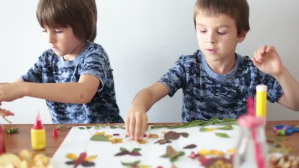 Παιδάκια Αγόρια Εφαρμόζοντας Φύλλα Χρησιμοποιώντας Κόλλα Ενώ Κάνοντας Τέχνες Και — Αρχείο Βίντεο