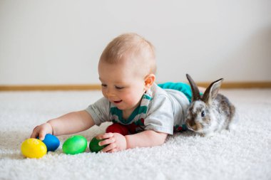 Bunnies ve Paskalya ile oynayan küçük yürümeye başlayan çocuk, bebek çocuk, 