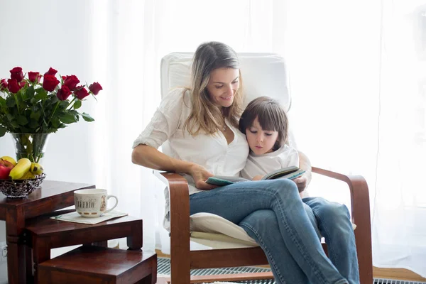 Mãe, lendo um livro para seu filho, sentada em cadeira de balanço — Fotografia de Stock