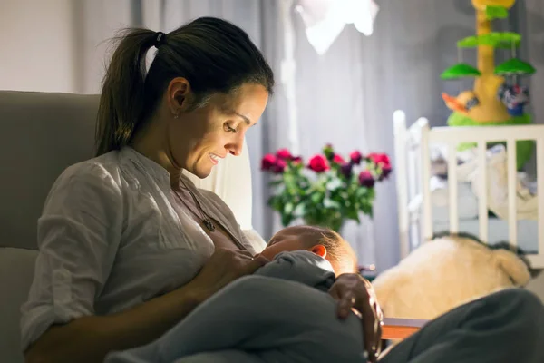 Jovem bela mãe, amamentando seu bebê recém-nascido menino em ni — Fotografia de Stock