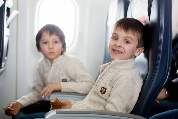 Due bambini, mangiare panini a bordo in aricraft, viaggiare — Foto Stock