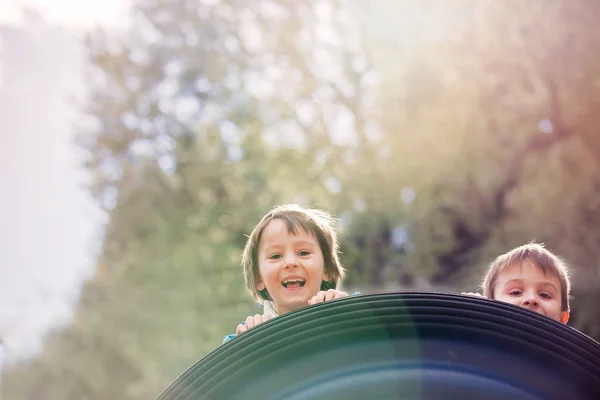 Dos niños preescolares en un columpio, divirtiéndose — Foto de Stock