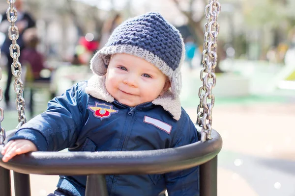 Kleiner Junge in einer Schaukel auf dem Spielplatz — Stockfoto