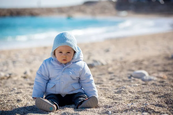 Bambino, che gioca sulla spiaggia con sabbia e ciottoli — Foto Stock