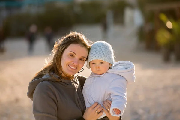 Bambino bambino e sua madre, giocando sulla spiaggia su un soleggiato da — Foto Stock