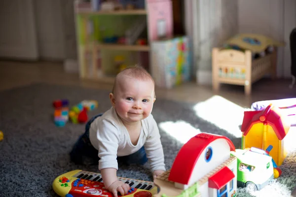 Lindo bebé niño pequeño, jugando con un montón de constructio colorido —  Fotos de Stock