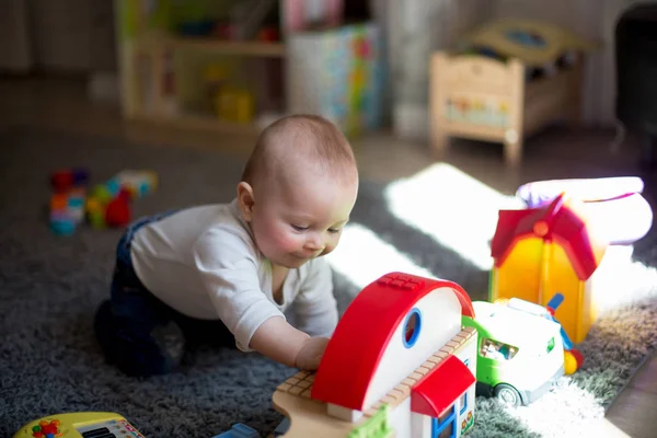 Söt baby småbarn pojke, spelar med massor av färgglada lastyta — Stockfoto
