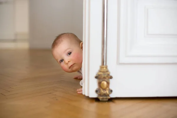 Lilla pojke, småbarn, i en lång hall, kryper på golvet — Stockfoto