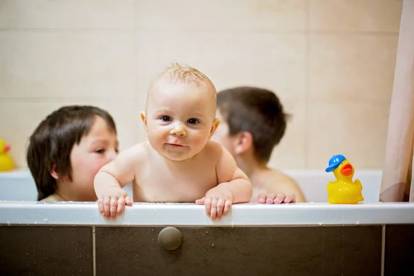 Menino, brincando com patos de borracha no tubo de banho — Fotografia de Stock