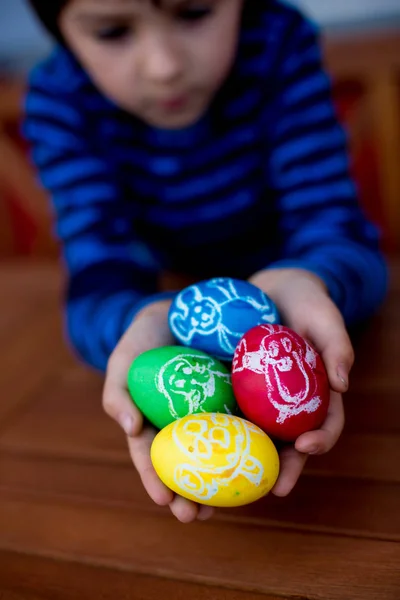 Барвисті великодні яйця з дитячими малюнками в руках дітей — стокове фото