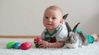 Bunnies ve evde, yumurta ile yumurta üzerinde renkli el çizimleri oynayan küçük yürümeye başlayan çocuk, bebek çocuk,.